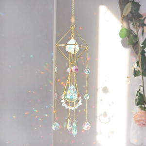 Detail of crystal suncatcher throwing rainbow light on wall with geometric gold frame