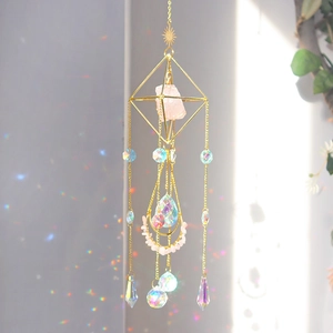 Detail of gold suncatcher with pink quartz and crystals reflecting rainbows on wall