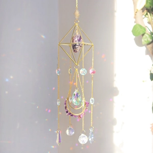 Detail of golden suncatcher with purple amethyst and crystals reflecting sunlight spots