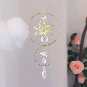 Close-up of golden lotus crystal suncatcher with faceted prism and sun charms