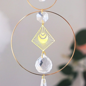 Detail of celestial gold suncatcher with moon, star metal frame and faceted crystal ball