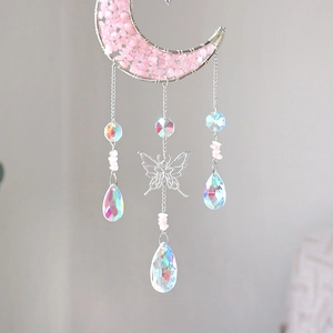 Detail of moon suncatcher with pink crystals, butterfly charm and iridescent drops