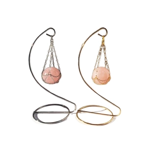 Rose quartz crystal ball pendants hanging on elegant gold and silver metal S-shaped stands
