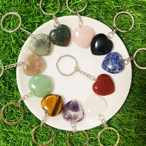 Flat lay of heart-shaped natural stone keychains in quartz and amethyst on a white plate