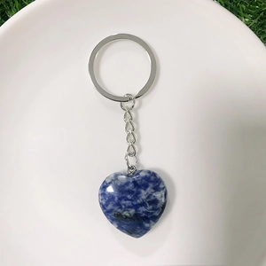 Macro detail of heart-shaped blue natural stone keychain with silver metal ring