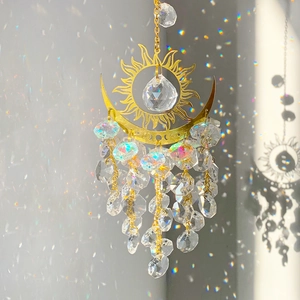 Macro shot of sun and moon crystal suncatcher reflecting rainbow light on white wall
