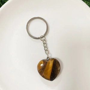 Close-up of heart-shaped tiger eye stone keychain with silver metal ring and chain