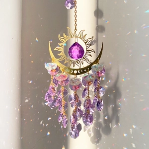 Detail of sun moon crystal suncatcher with amethyst beads creating rainbow light