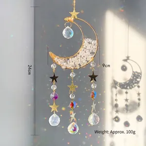 Golden crescent moon suncatcher with amethyst crystals and stars hanging on a wall