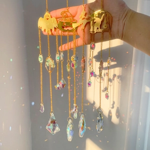 Detailed view of Halloween themed crystal suncatchers with metal ghost and pumpkin charms