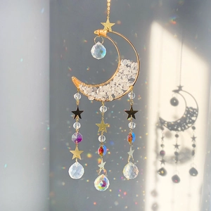 Detail of golden moon suncatcher with crystals creating rainbow light refraction