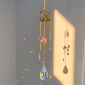 Detailed suncatcher with crystal prism reflecting rainbows from a golden cat silhouette