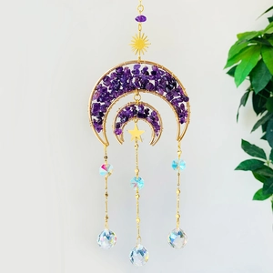 Detail of bohemian suncatcher with double moon frame, purple amethyst and crystal prism