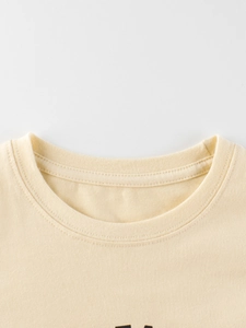 Neckline detail of a cream cotton long-sleeve T-shirt with fine ribbed stitching