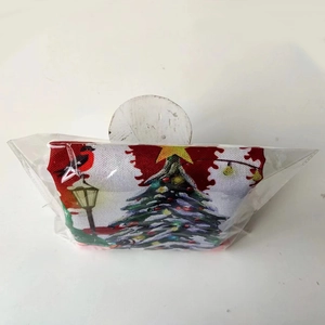 Detail of Christmas themed fabric gift bag with festive tree and red bird prints