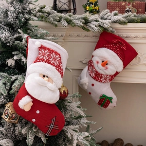 Knitted Christmas stockings with Santa and Snowman hanging by a fireplace scene