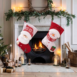 Detail of Christmas stockings with Santa and snowman motifs hung on a rustic fireplace