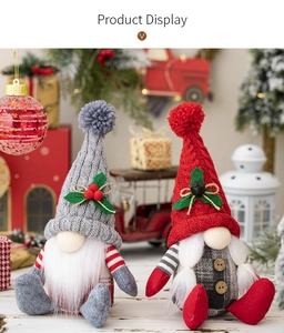 Detail of handmade knitted Christmas gnomes with berries and bells on a festive background