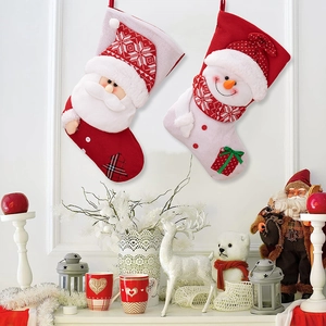 Detail of knitted Christmas stockings with 3D Santa and Snowman plush appliques