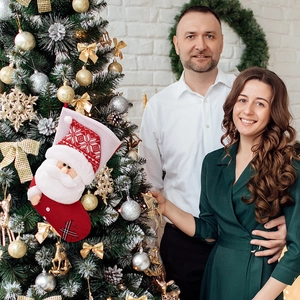 Detail of red knitted Christmas stocking with 3D Santa Claus hanging on a festive tree
