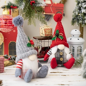 Detailed view of two sitting Christmas gnomes with knitted hats and long white beards