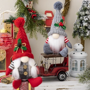 Detail of Christmas gnomes with knitted hats and holly leaves in a cozy holiday scene