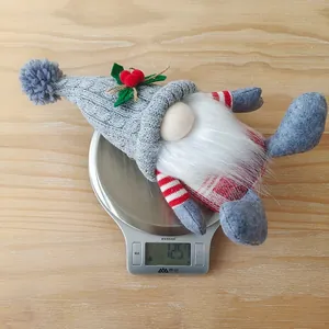 Detailed view of a sitting Christmas gnome plush weighing 125.7g on a digital scale