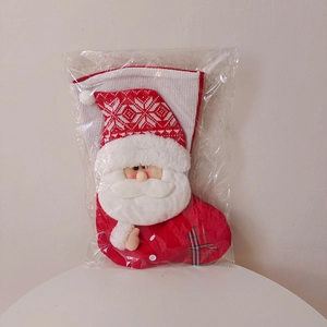 Close-up of a knitted Christmas stocking with 3D Santa Claus doll in original packaging