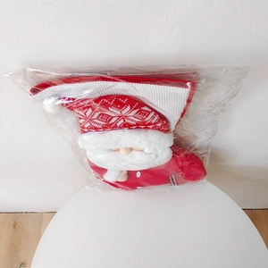 Detail view of a red knitted Christmas stocking featuring a 3D Santa Claus doll and snowflakes