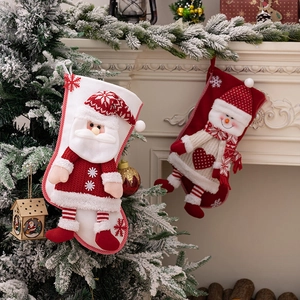 Detail of hanging Christmas stockings with 3D Santa and Snowman plush on a fireplace