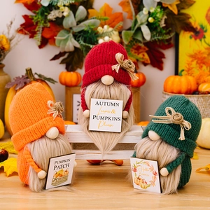 Set van drie herfstkabouters met gebreide mutsen en pompoenborden voor decoratie