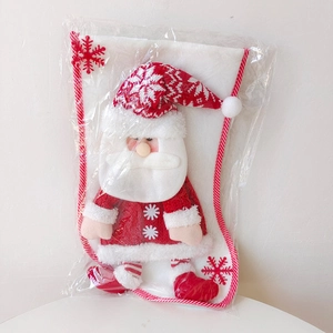Detail of a white velvet Christmas stocking featuring a 3D plush Santa in red sweater