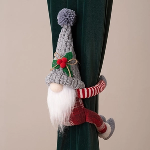 Gros plan d'une attache-rideau gnome de Noël avec bonnet tricoté gris sur velours vert