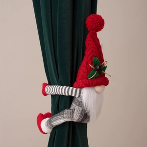 Détail d'un embrasse de rideau gnome de Noël tricoté avec clochette sur velours vert