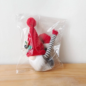 Détail d'un gnome de Noël avec bonnet rouge tricoté et longues jambes rayées