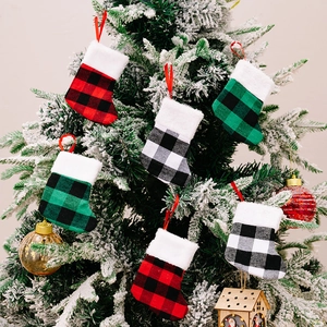 Buffalo plaid Christmas mini stocking ornaments set on a frosted pine tree