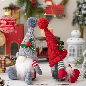 Pair of sitting Nordic Christmas gnomes with knitted hats and white beards decorations