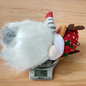 Détail d'un gnome de Noël avec bois de renne pesant 140g sur une balance électronique