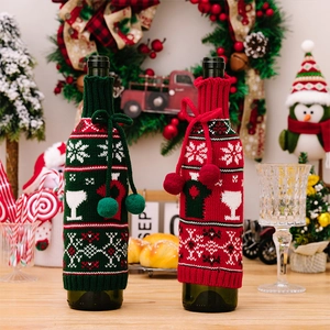 Detail of red and green knitted Christmas wine bottle covers with snowflake jacquard patterns