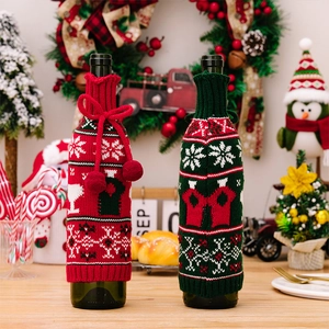 Detail of red and green knitted Christmas wine bottle covers with reindeer and snowflake patterns