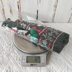 Macro shot of a green Christmas knit bottle cover with snowflake pattern weighing 327.1g