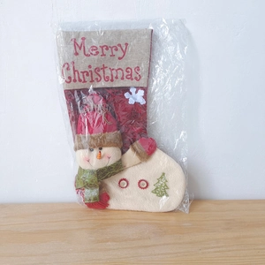Detail eines roten Leder-Weihnachtsstiefels mit Schneemann-Motiv und Merry Christmas
