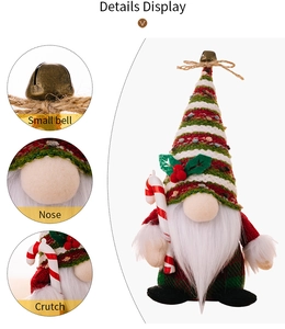 Detail view of Christmas gnome with striped knit hat, bell, and candy cane accessories