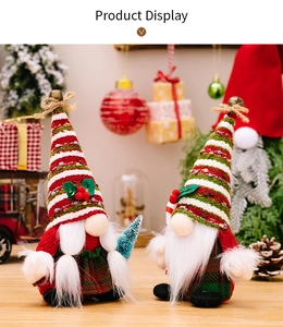 Detail of Christmas gnomes with striped knit hats holding small pine trees for decor