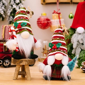 Detail of Christmas gnomes with striped hats holding candy cane and mini Xmas tree