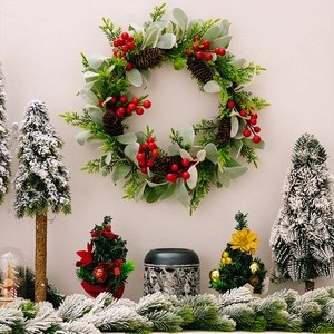 Detailansicht eines Weihnachtskranzes mit roten Beeren, Zapfen und grünen Blättern