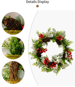 Detailansicht vom Weihnachtskranz mit Zapfen, roten Beeren und beflockten Blättern