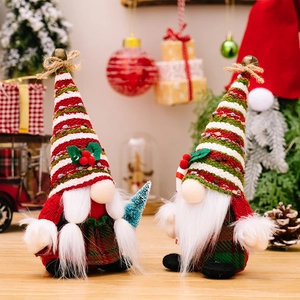 Set of two Christmas gnomes with striped knit hats holding tree and candy cane