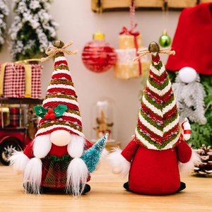 Set of two Christmas gnomes with striped knit hats, holding a tree and candy cane