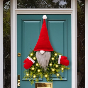Detail of Christmas gnome wreath with glowing LED lights on a green evergreen base